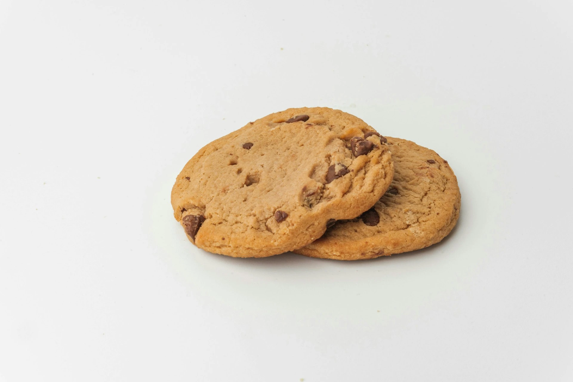 Two chocolate chip cookies on a white plate